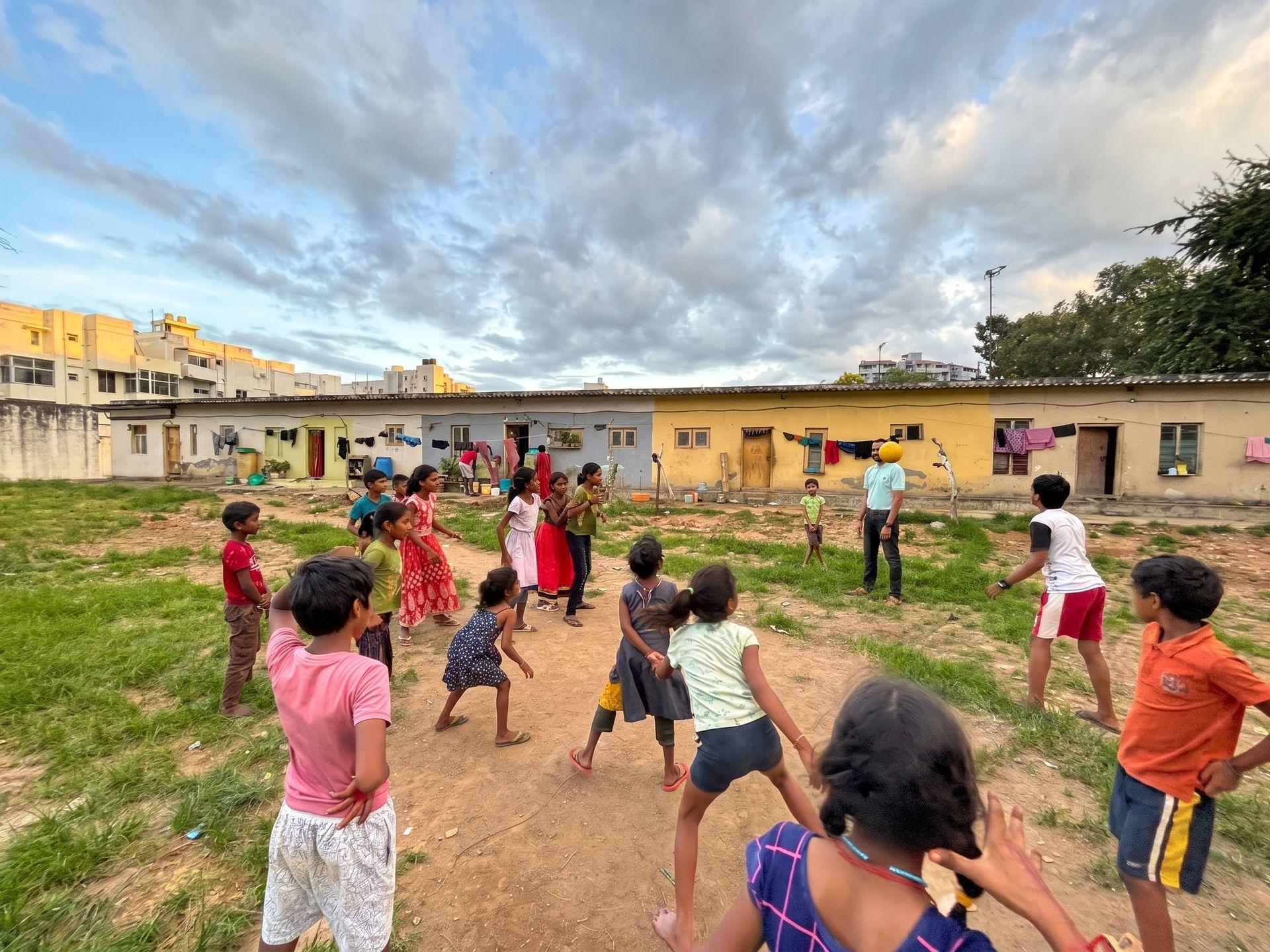 A coach and children playing together in an open field