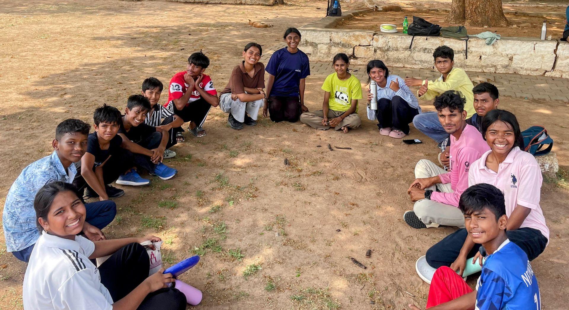 Children and coaches sitting together in a reflection circle after a session